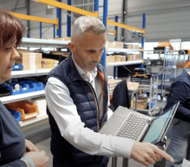 Le directeur d'usine de Socomec montre un indicateur à une opératrice en usine