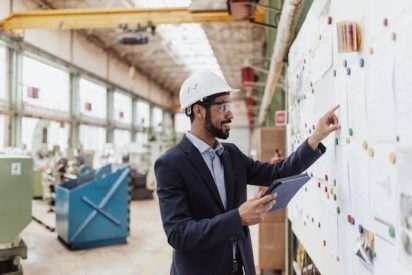 Un manager utilise un tableau Kanban en usine de production