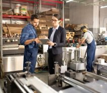 Factory team members on shop floor exemplifying shop floor management practices like gemba walks and using a digital daily management system.