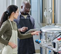 Two manufacturers solving problems on the shop floor with a digital fishbone diagram (or Ishikawa) diagram on their ipad.