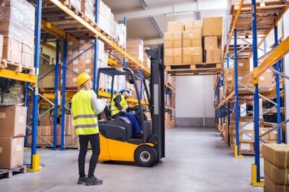 Value Stream Mapping (VSM) example in a warehouse with a forklift and many moving parts of a manufacturing process.