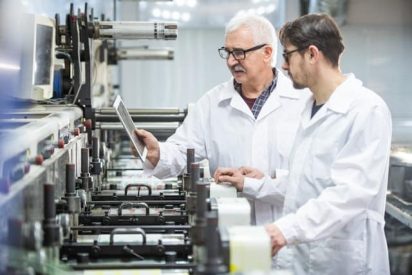 Manufacturing team using Lean Six Sigma methods to analyze production performance and improve processes.