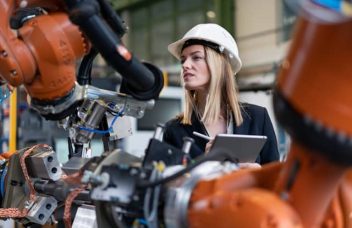 Eine Frau, die die 5-Why-Methode in einer Fabrik anwendet