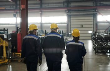 Factory workers collaborating on the shop floor in a manufacturing plant, illustrating knowledge sharing and operational teamwork.